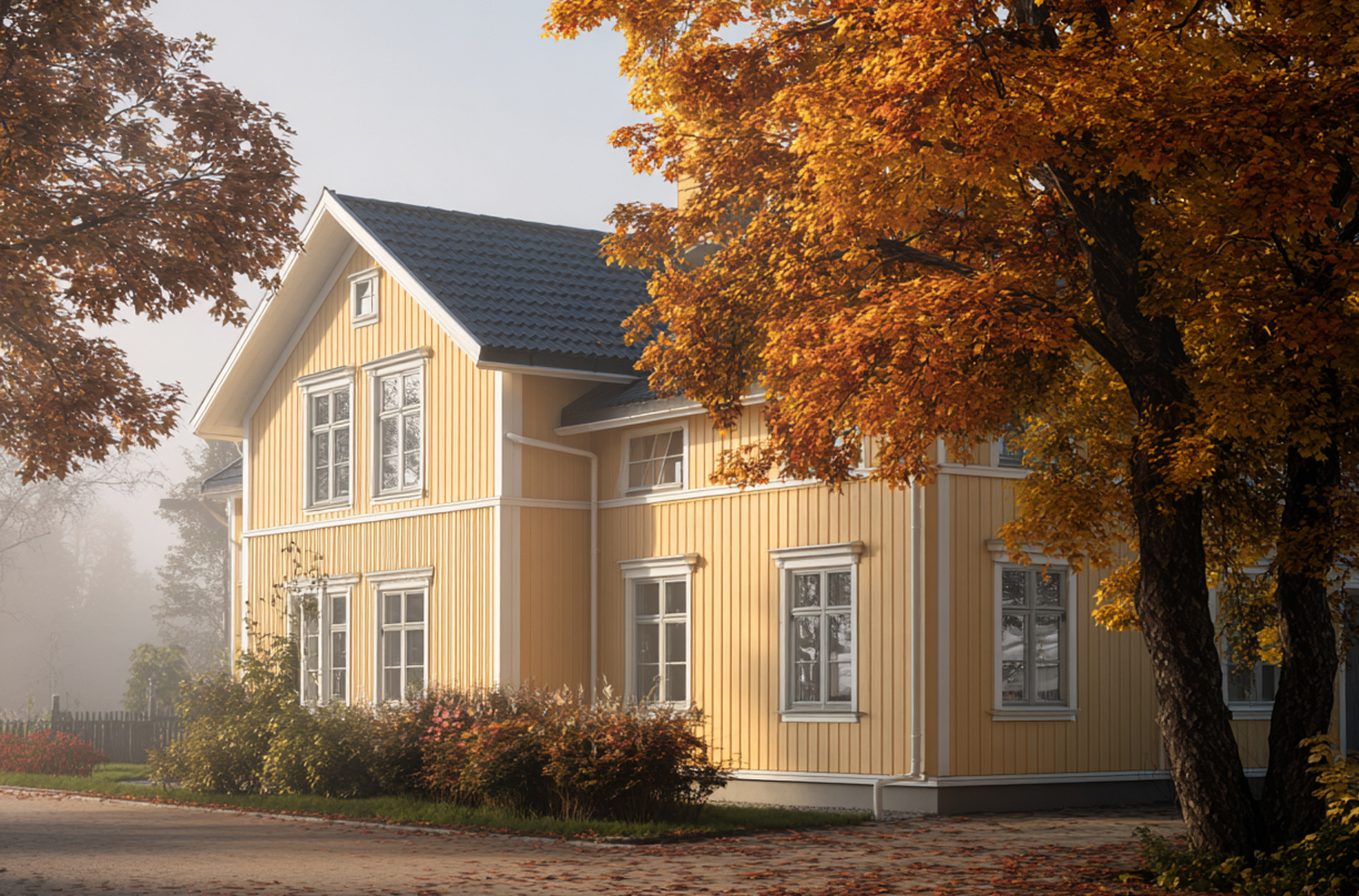 Klassisk svensk trävilla med gul träfasad i höstmiljö.